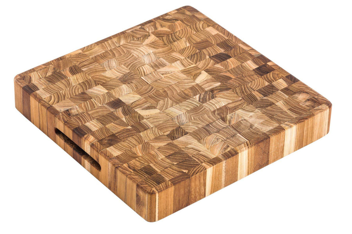 Thick square teakwood butcher block cutting board with end grain pattern and side hand grips.