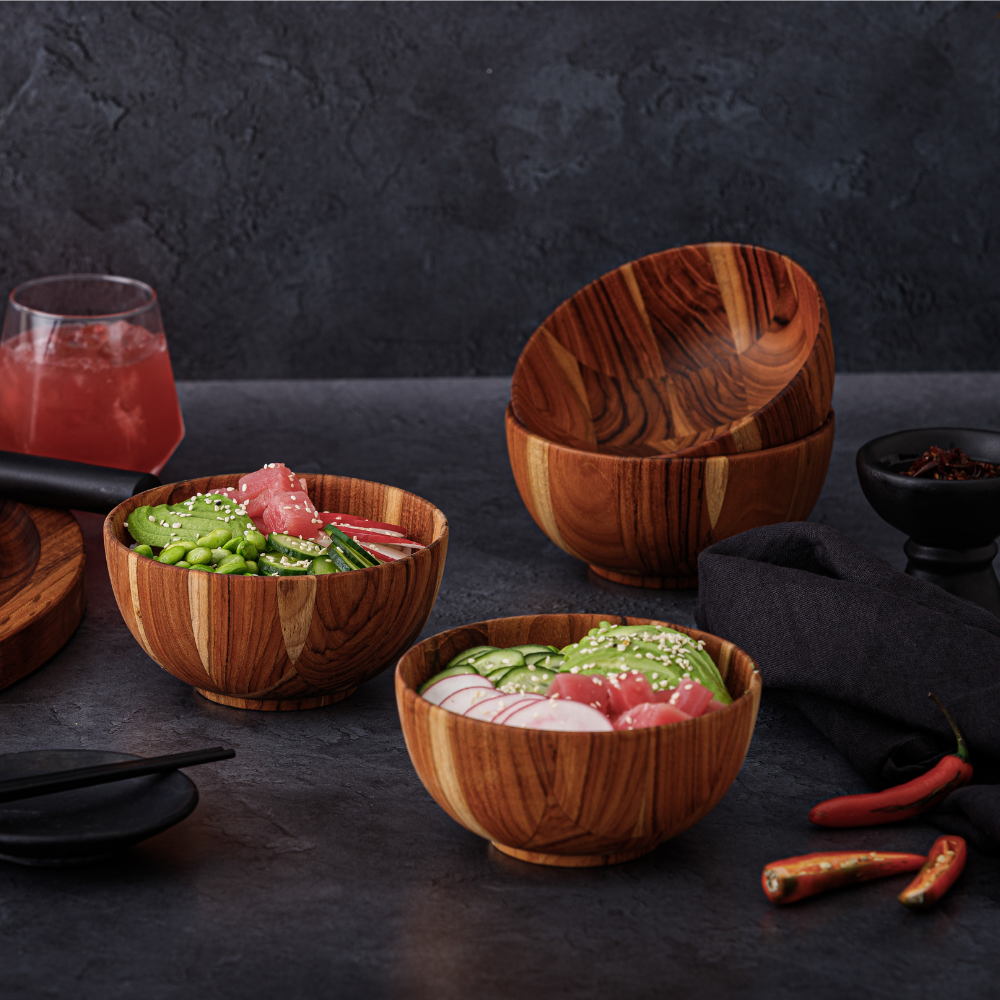 Teakwood Moon serving bowls filled with fresh tuna poke and vegetables on a dark, textured tabletop.