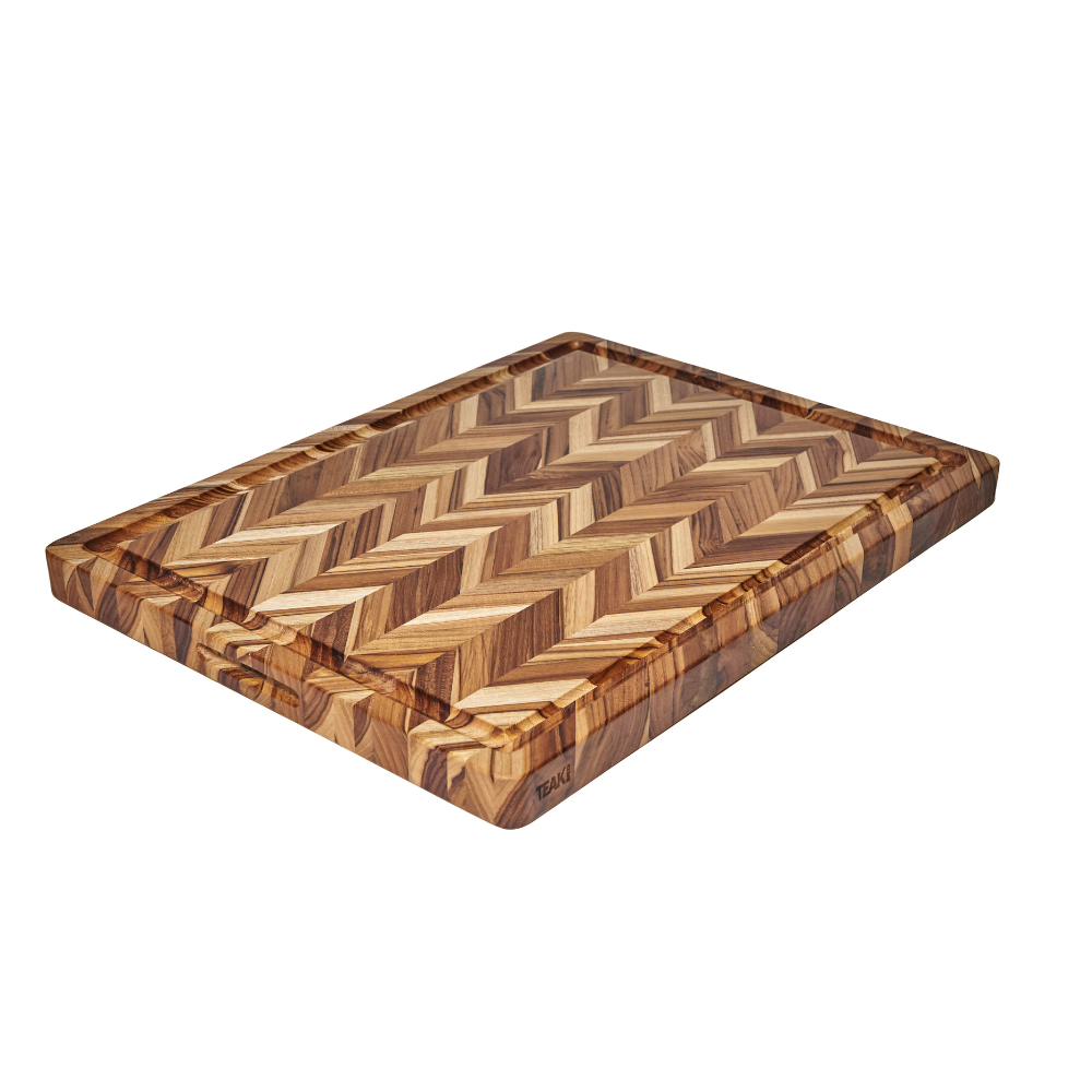 Extra large teakwood cutting board with a herringbone pattern and juice groove on a white background.