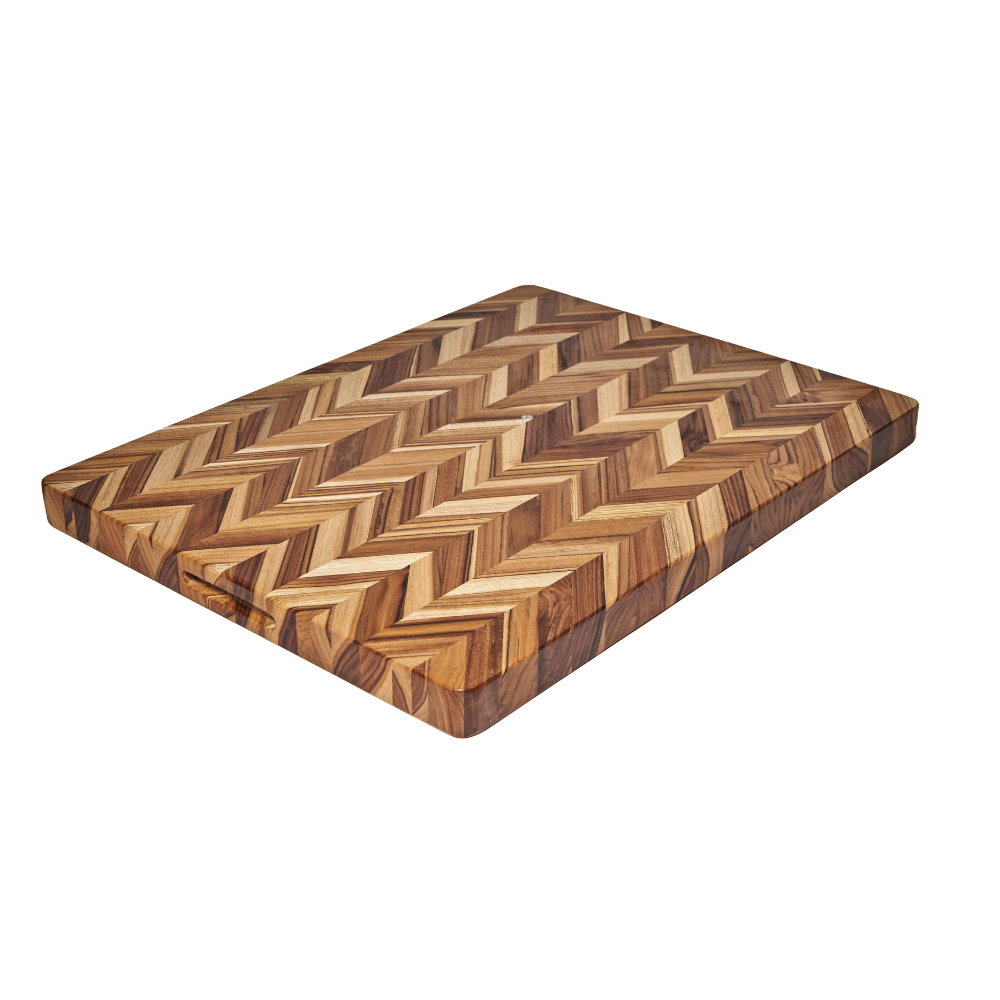 Extra large teakwood herringbone cutting board with multi-toned grain on a white background.