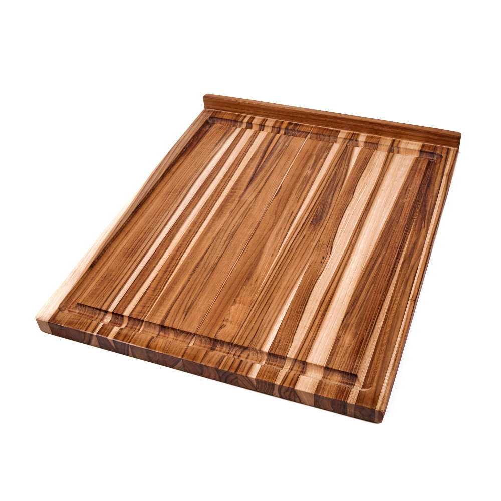Large edge grain teakwood countertop board with an anchoring lip and juice canal against a white background.