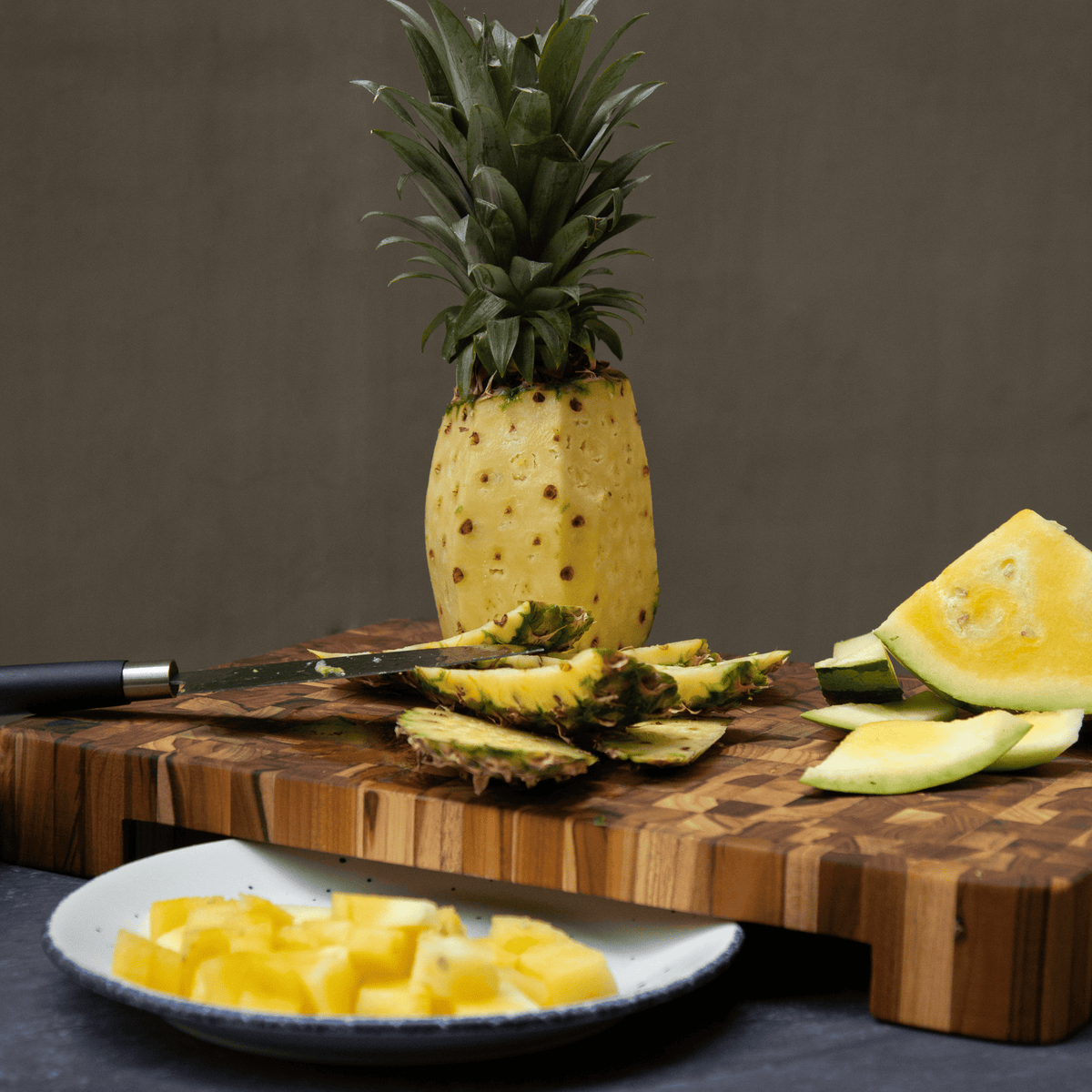 Extra thick end grain teak butcher block featuring a plate cutout for efficient fruit prep.