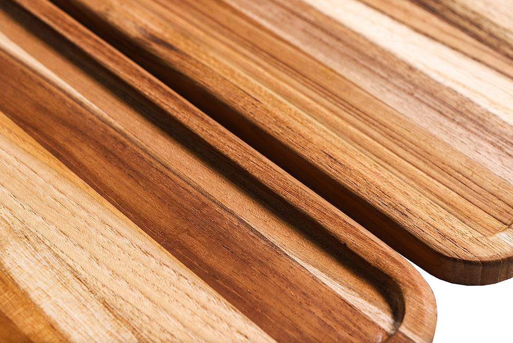 Close-up of the small rectangular teakwood serving tray showing natural edge grain and raised borders.