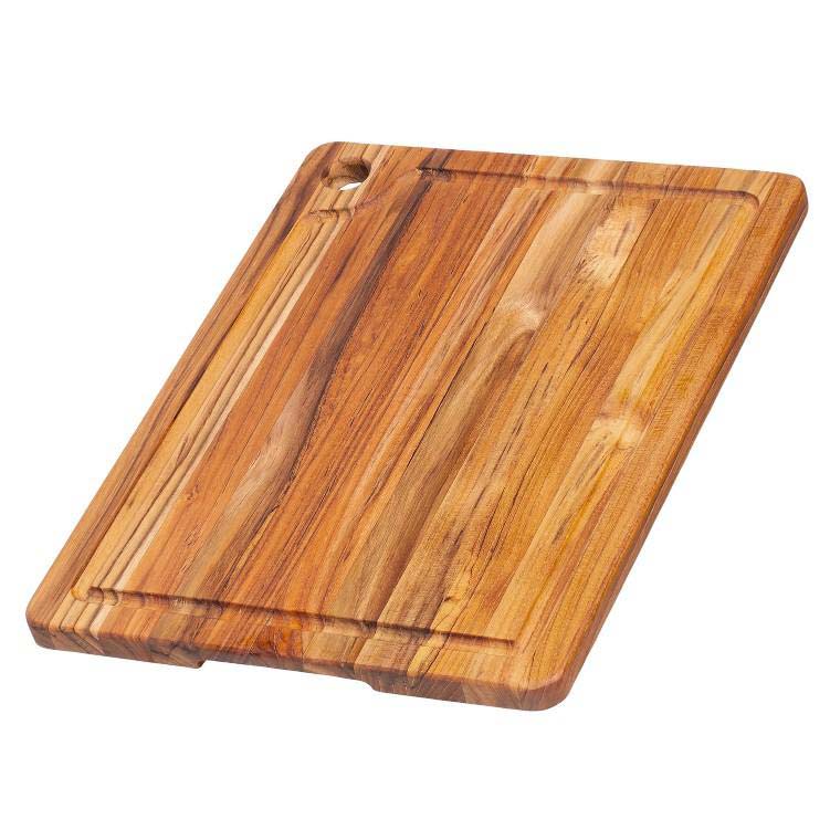 Rectangular teakwood cutting board featuring an edge grain finish, perimeter juice canal, and a functional corner hole.