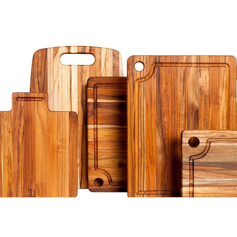 Teakwood cutting boards from the Marine Collection featuring juice canals, corner holes, and rich edge grain patterns.
