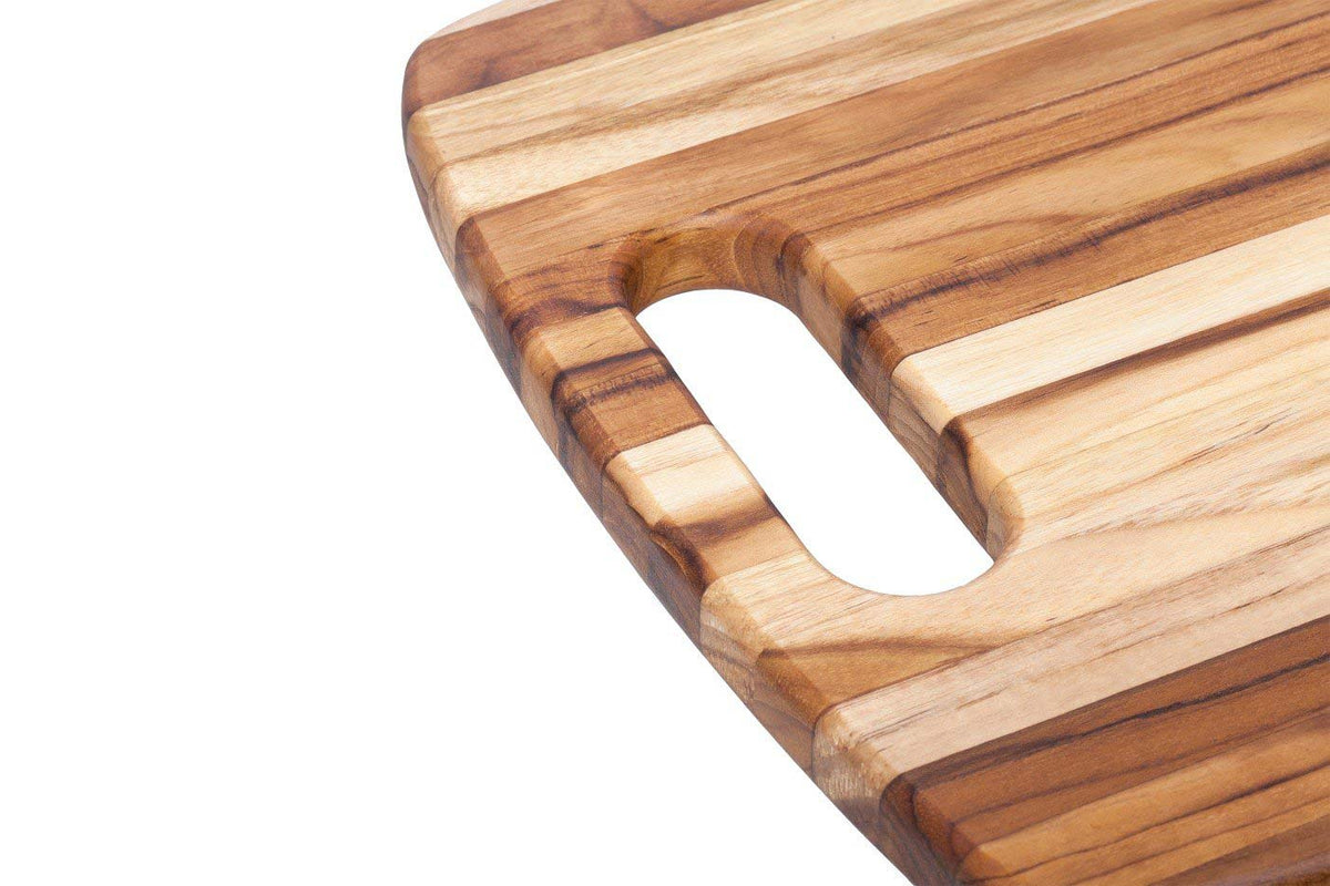 Edge grain teak chopping board corner featuring a rounded hole handle and natural wood grain patterns.