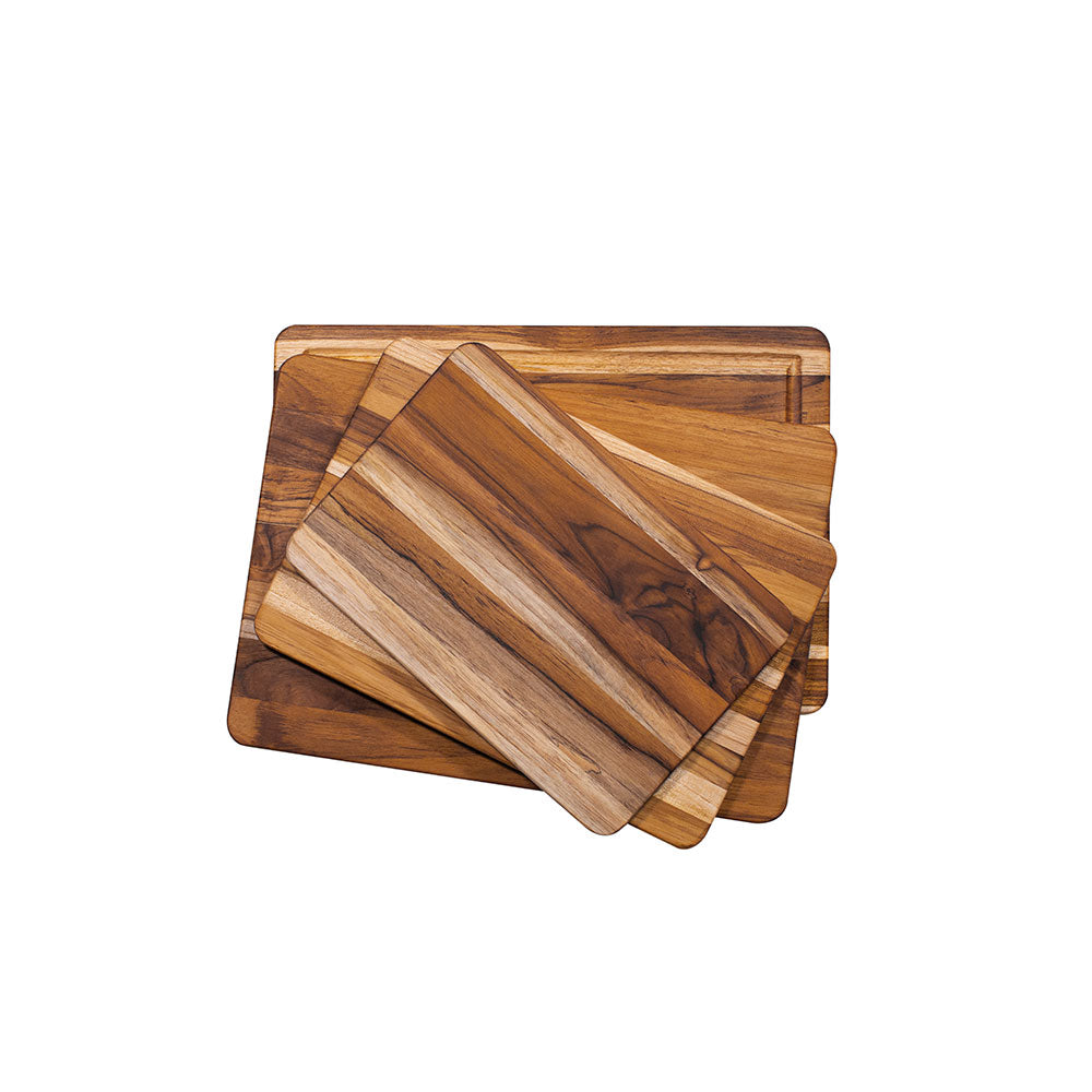 Stacked rectangular teakwood cutting boards in various sizes, featuring natural edge grain and rounded corners.