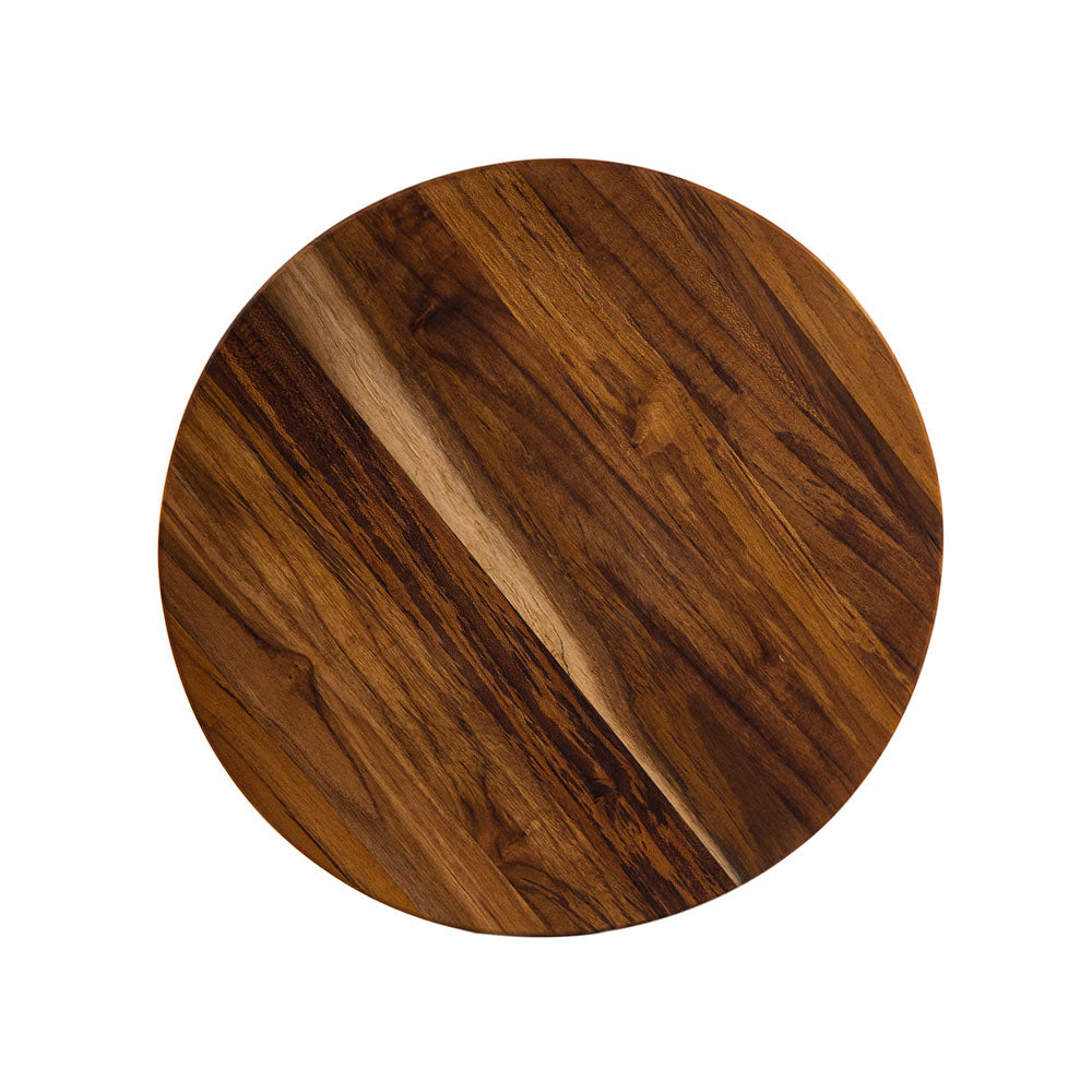 Large round teakwood cutting board with a dark edge grain finish for kitchen food preparation and serving.