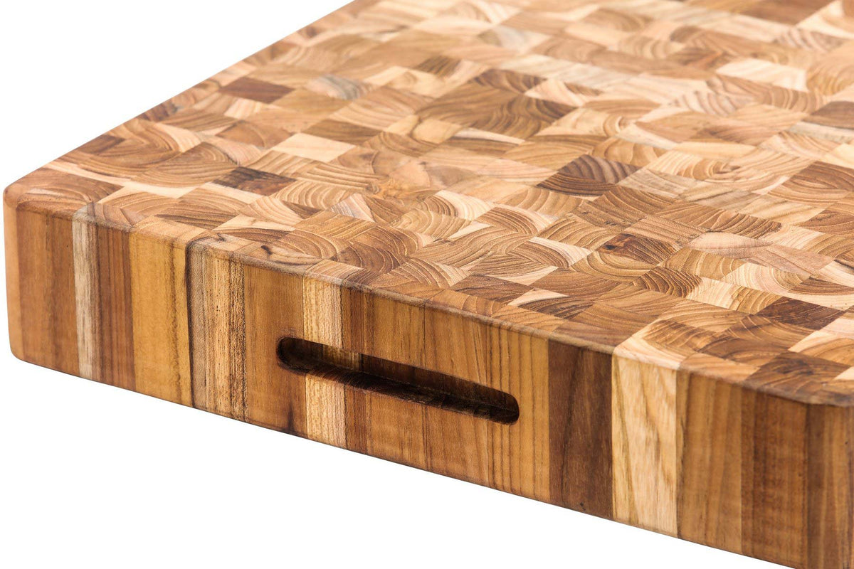 Extra-thick teak end-grain butcher block with a mosaic wood pattern and a built-in hand grip for easy handling.